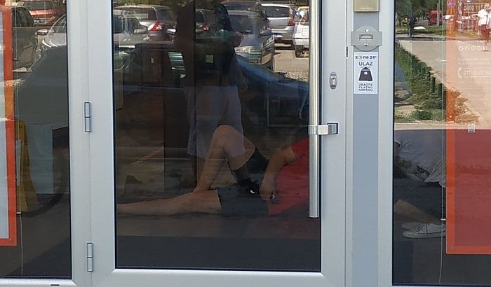 FOTO: Legao na ulaz u banku jer nisu hteli da ga puste bez maske